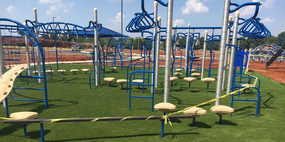 A newly installed blue and beige playground structure on vibrant synthetic grass, ready for active play, highlighting the safety and aesthetic appeal of our artificial turf in recreational areas.